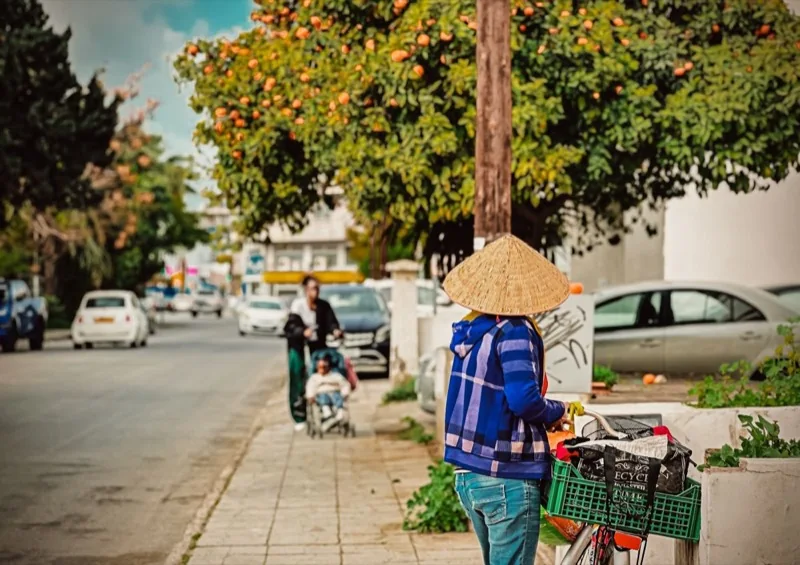 street scene in larnaca with cyclist and orange trees — illustrative editorial photography, not a verified location