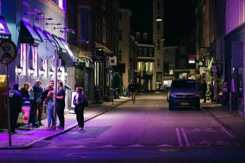 people on street in city at night — illustrative editorial photography, not a verified location