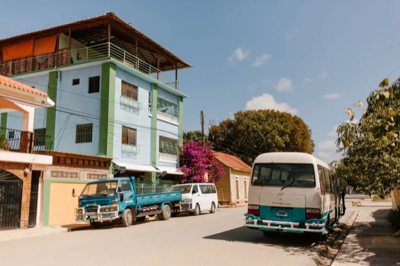 old house facades near road with transport in summer town — illustrative editorial photography, not a verified location