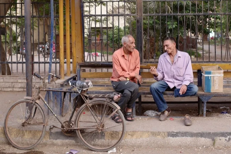 two men chatting on bench in cairo egypt — illustrative editorial photography, not a verified location