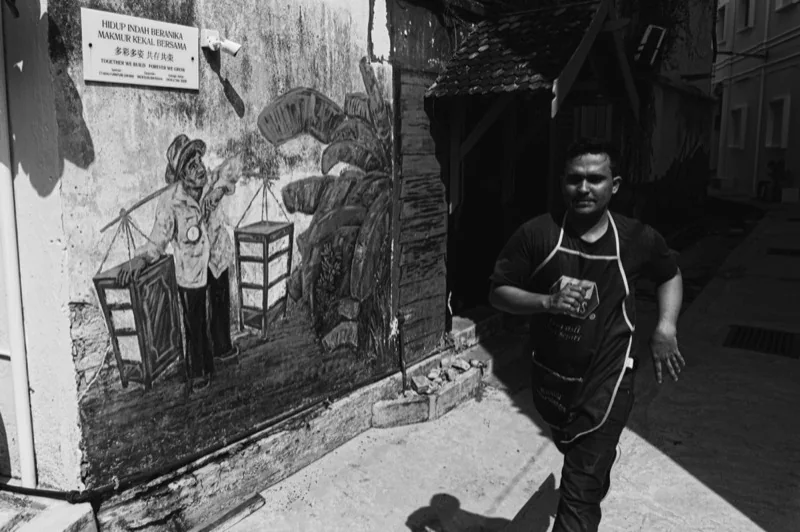 man in apron walking on street — illustrative editorial photography, not a verified location