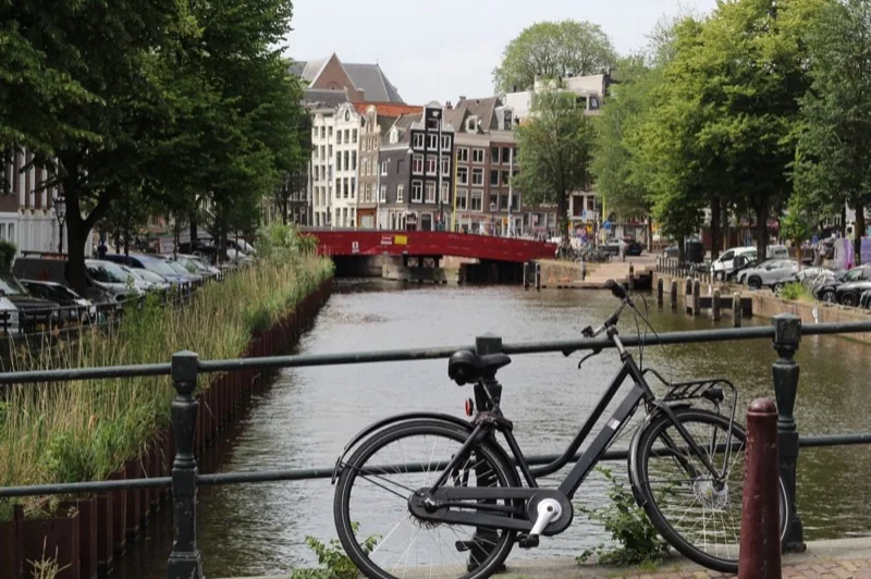 scenic amsterdam canal with bicycle and bridge — illustrative editorial photography, not a verified location
