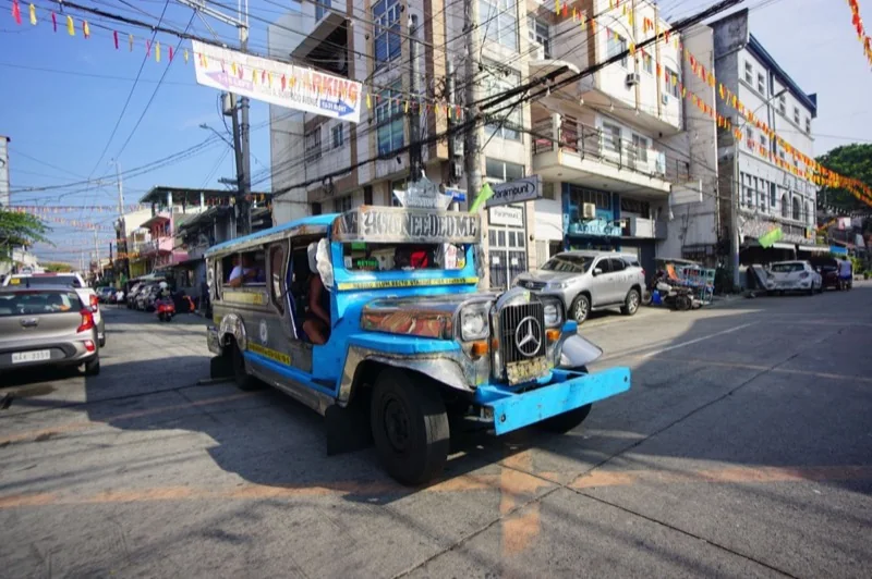 colorful jeepney navigating busy urban street — illustrative editorial photography, not a verified location