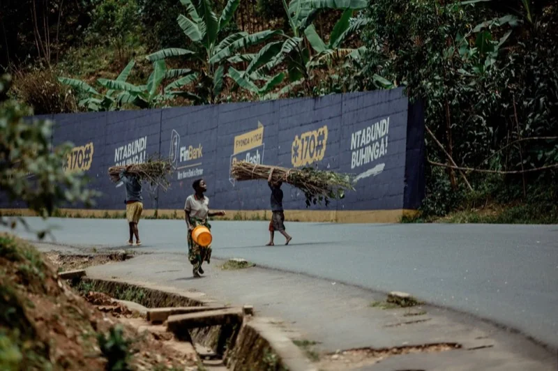 street view of three people carrying wood — illustrative editorial photography, not a verified location