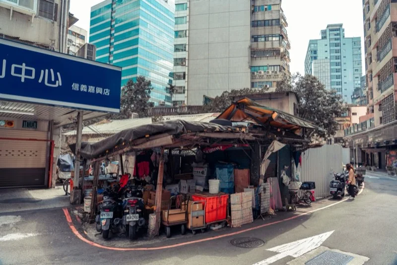 scooters parked by street market in city — illustrative editorial photography, not a verified location
