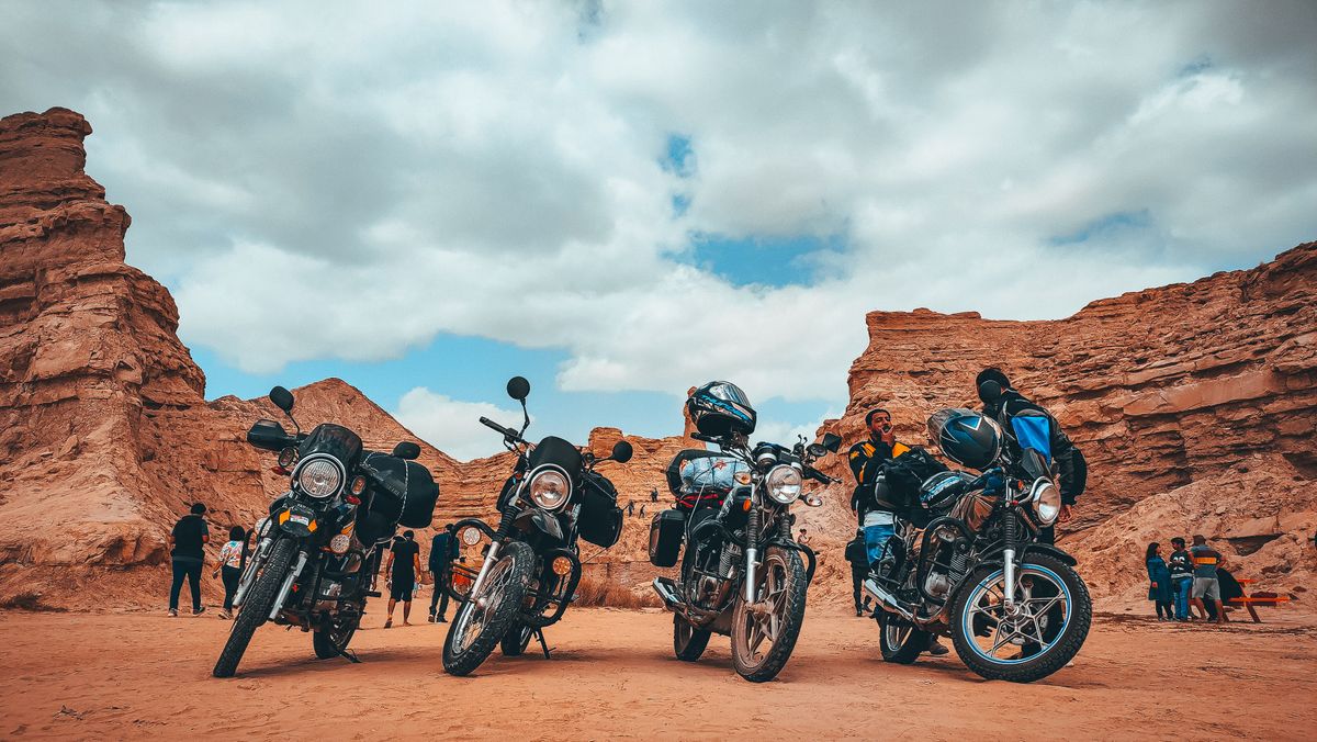 Motorcycles and riders beside a desert canyon